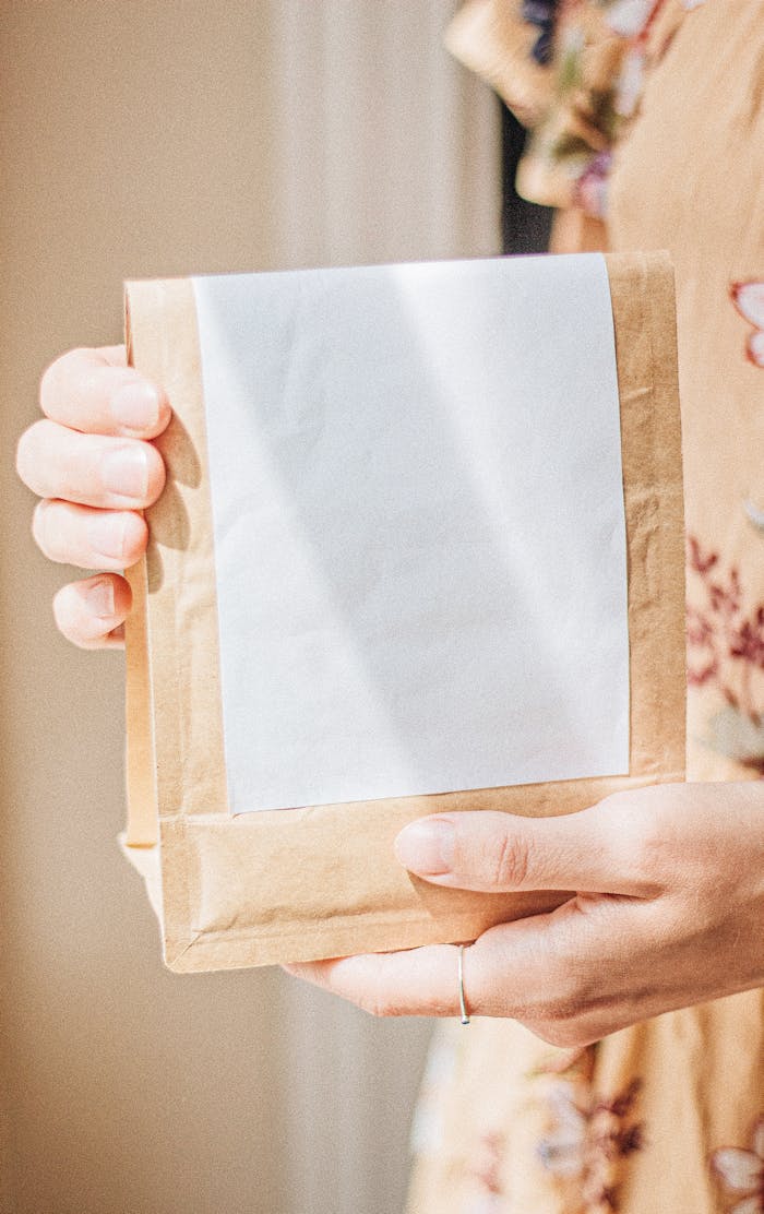Minimalist brown coffee bag held with a blank label, perfect for branding and packaging concepts.